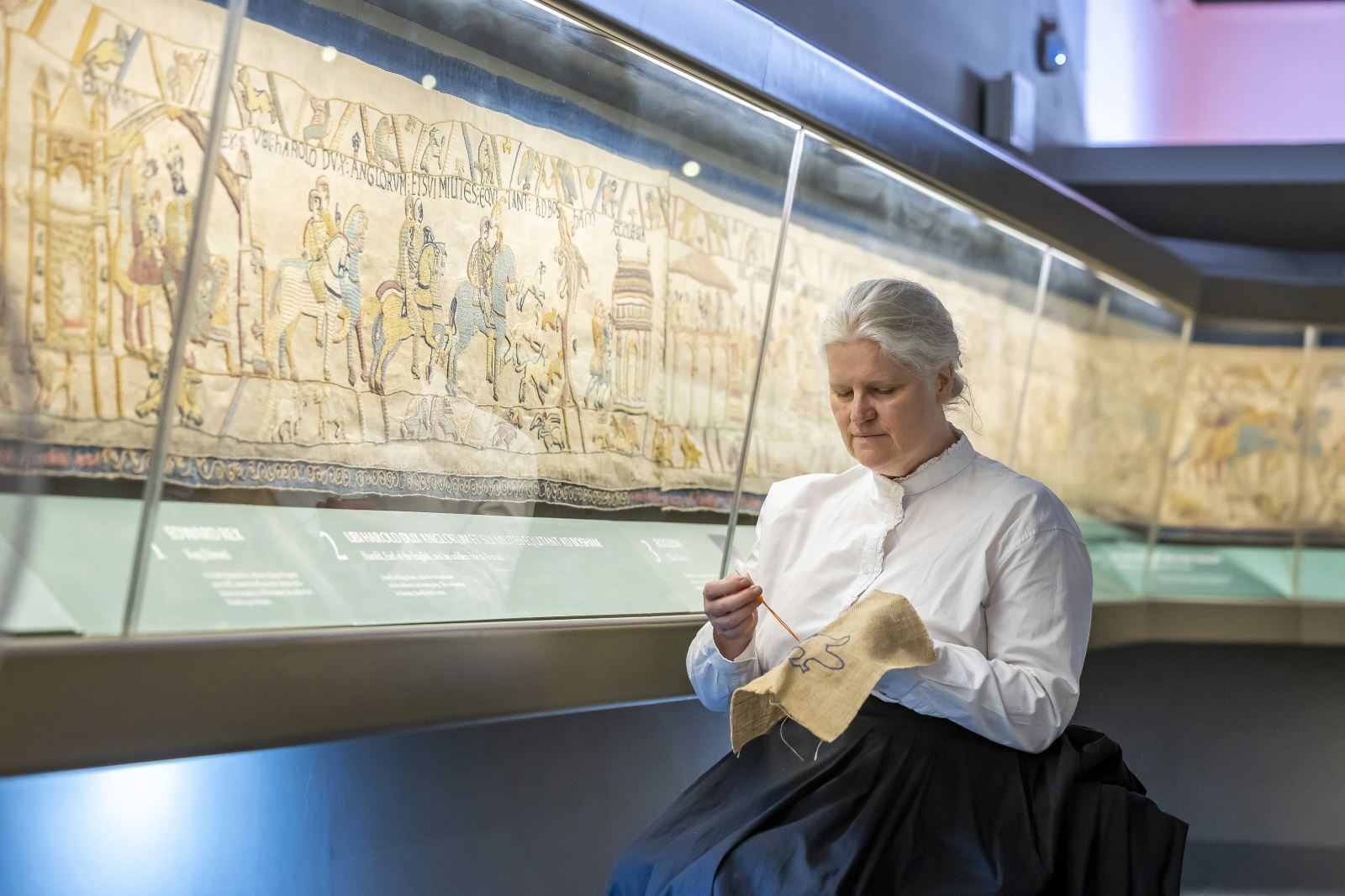 Britain's Bayeux Tapestry with Victorian woman embroidering beside it